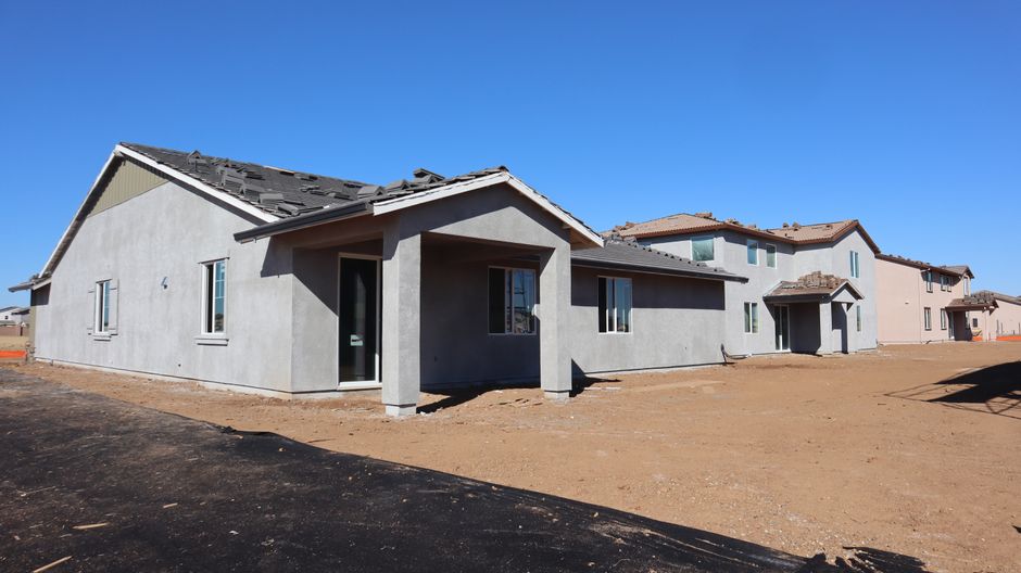 Newly constructed suburban homes under a clear blue sky, showcasing modern architecture.